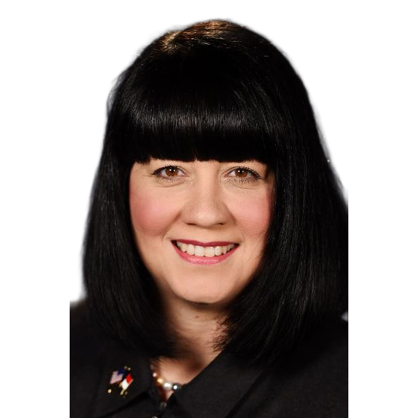 Headshot of a person with black hair and bangs smiling against a light gray background.