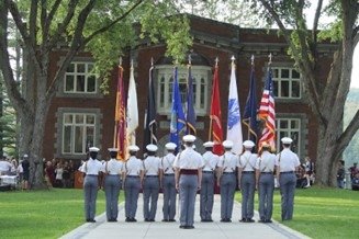 Norwich Alumni Weekend March Down, Color Guard walking on UP with flags.