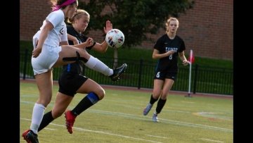 A member of the women's soccer team snatches the ball as she drives it by St. Joseph defender on her way to scoring.